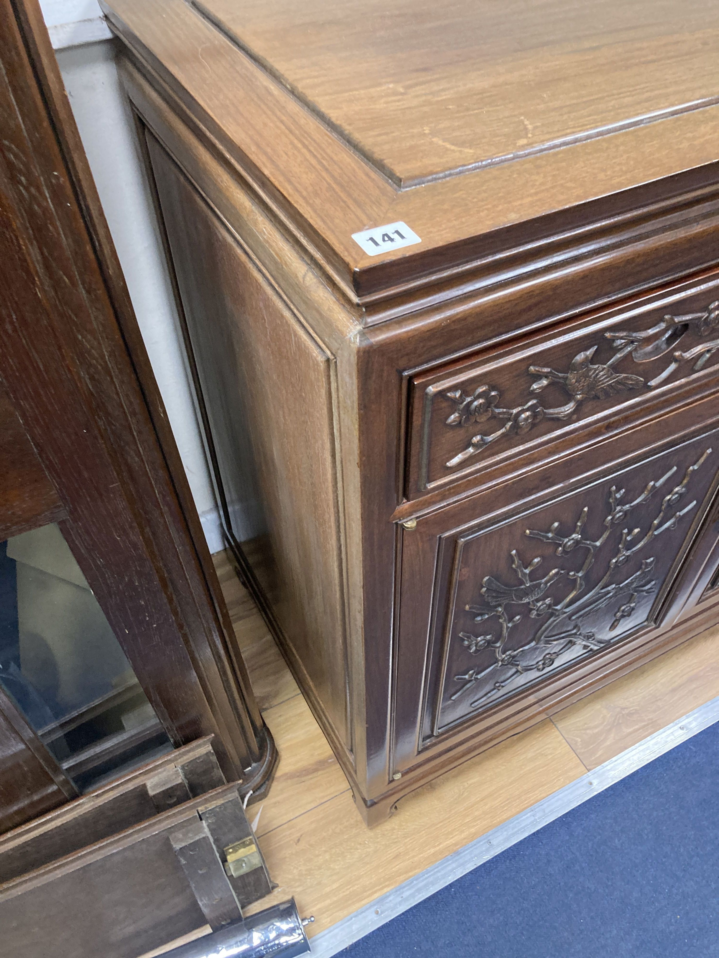 A 20th century Chinese carved hardwood dining room suite comprising sideboard fitted with four drawers above four carved panelled cupbo